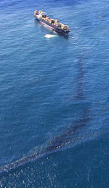 Oil streams from the Rena stuck on Astrolabe Reef in New Zealand's Bay of Plenty Oil