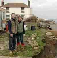 couple standing on edge of eroding cliff