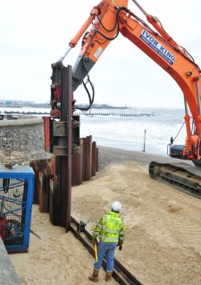 Steel piling being placed to front the old flint sea wall at Lowestoft